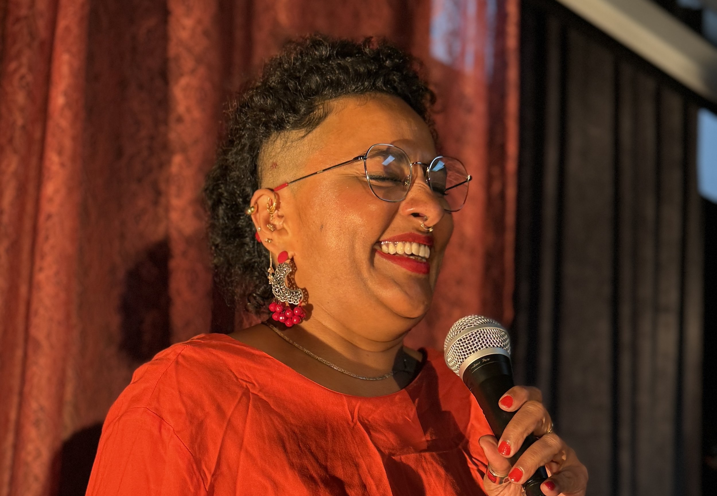 Vishnu laughing on stage with a microphone