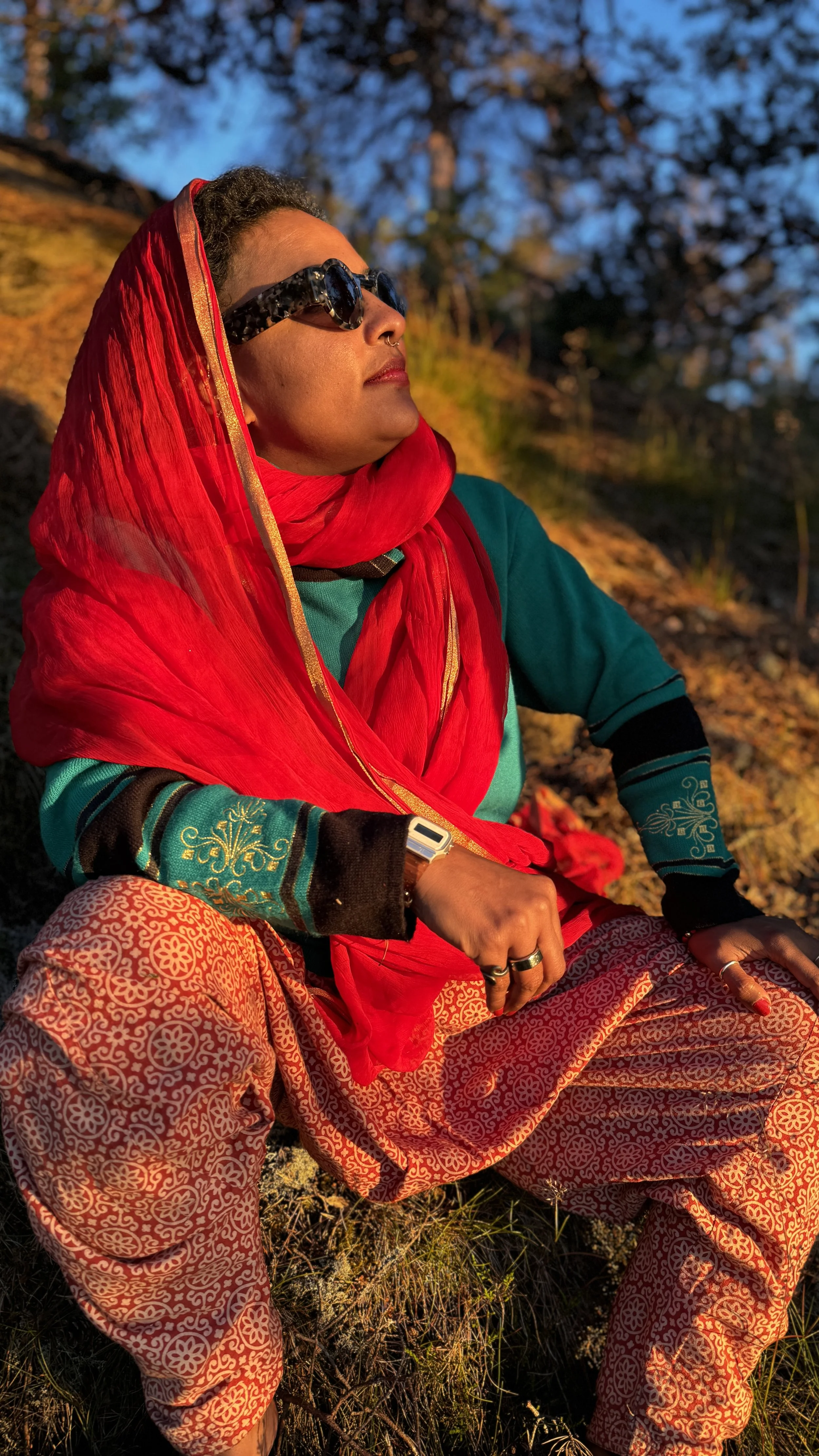 Vishnu Vardhani Rajan outdoors in a red headscarf and sunglasses