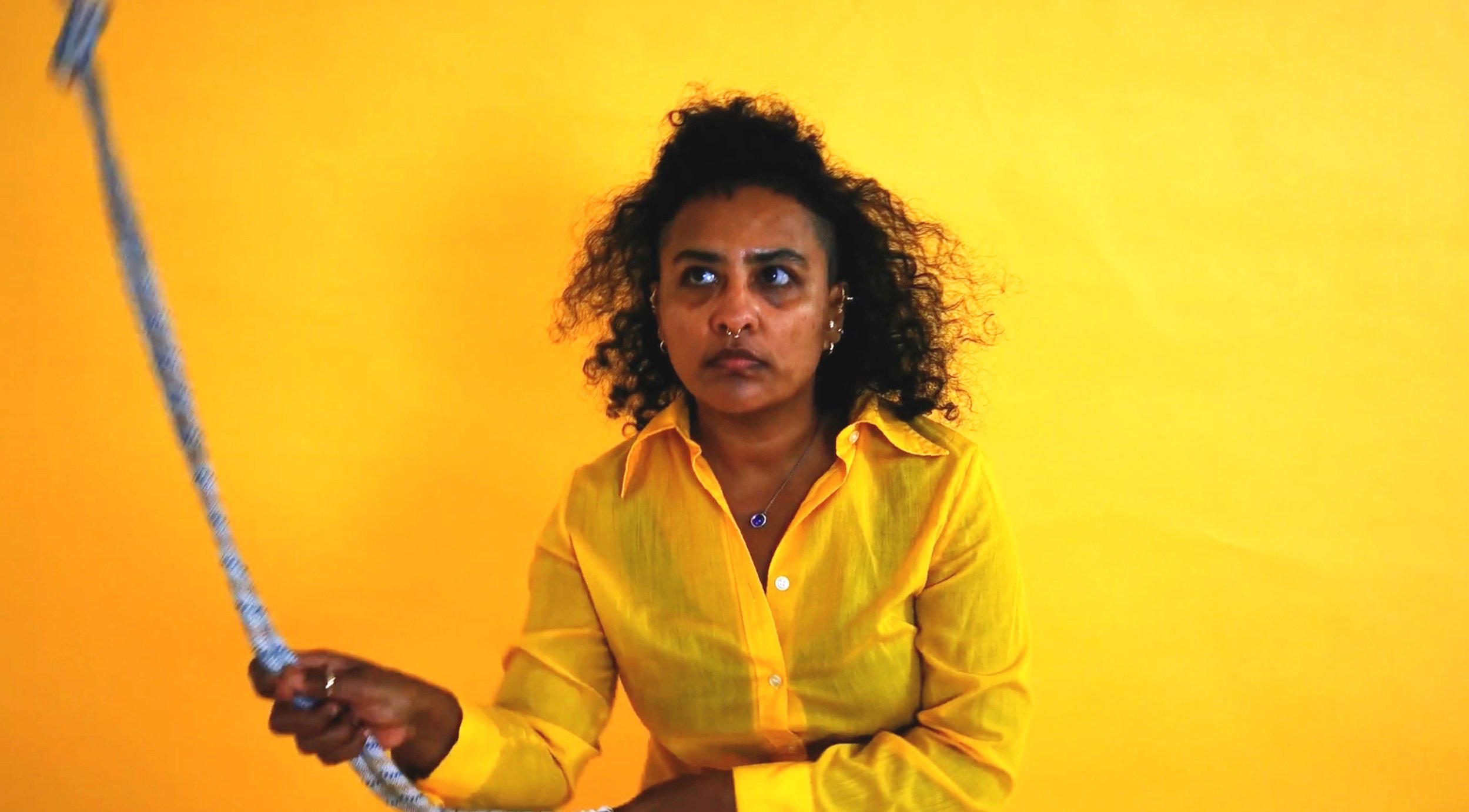 Vishnu in a film still against a yellow background